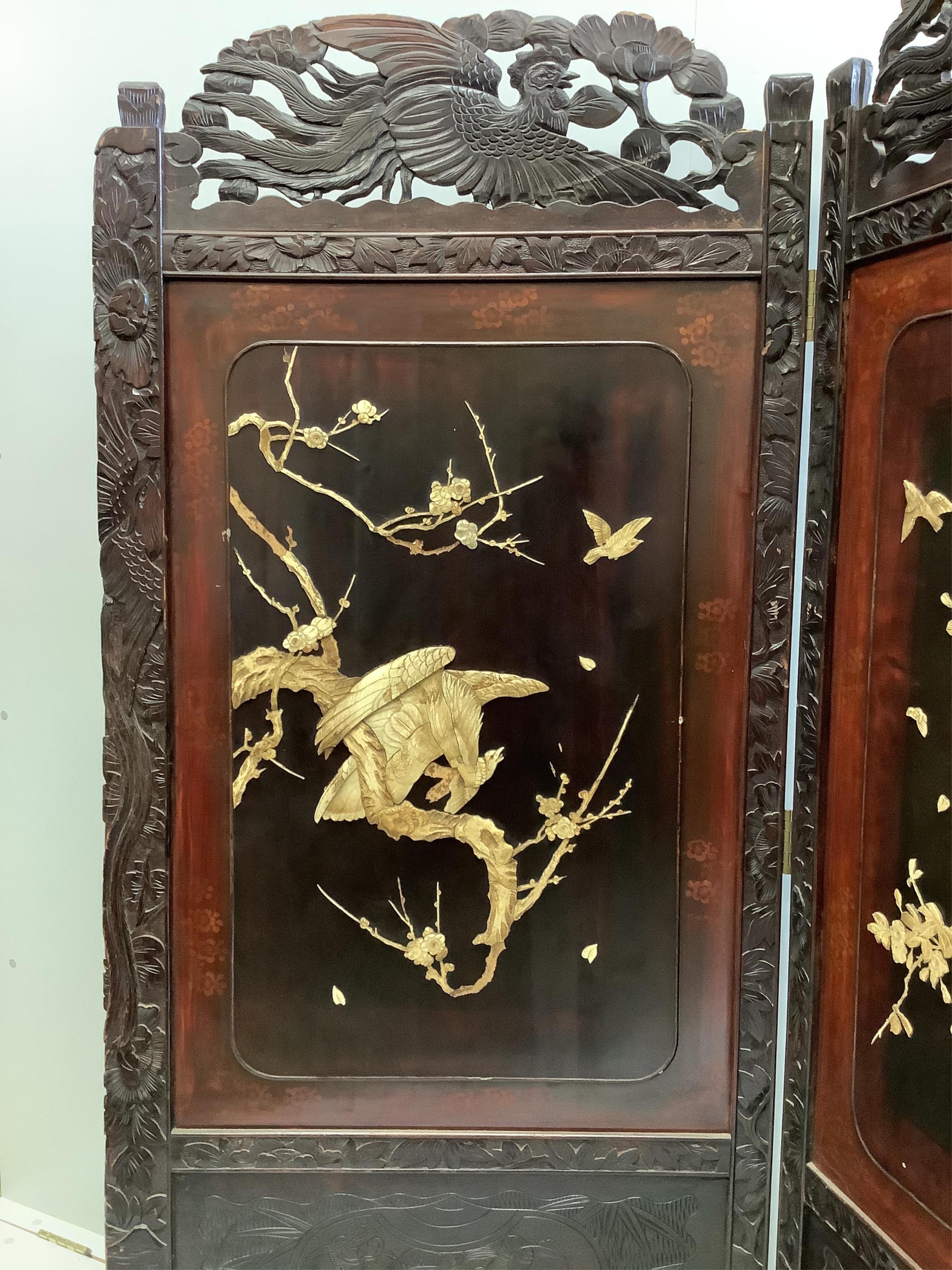 A Japanese carved wood bi-fold screen inset with lacquer and bone ‘eagle’ panels, each panel, width 79cm, height 180cm. Condition - fair